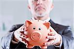 executive businessman asking more savings by showing a piggy bank