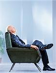 business man relaxing on an armchair with his eyes closed