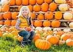 Portrait of happy child sitting on pumpkin