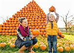 Portrait of happy mother and child pumpkin in front of pumpkin piramide
