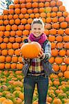 Portrait of smiling young woman holding pumpkin