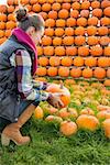 Young woman holding pumpkin. rear view