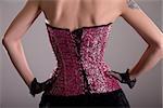 Rear view of elegant woman wearing purple corset with floral pattern