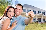 Mixed Race Excited Military Couple In Front of New Home Showing Off Their House Keys.