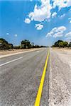 Endless road in Namibia, Caprivi Game Park, with blue sky