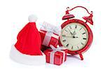 Christmas clock, gift boxes and santa hat. Isolated on white background