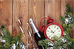 Christmas wooden background with clock, champagne, snow fir tree and copy space