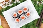 Sushi maki set and sakura branch on bamboo table