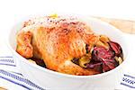 Grilled golden whole chicken in baking dish. Delicious traditional chicken.