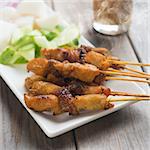 Chicken sate or satay, skewered and grilled meat, served with peanut sauce. Delicious hot and spicy Asian dish. Fresh cooked with steamed and smoke.