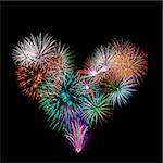 a group of exploding fireworks shaped like a heart in the night sky