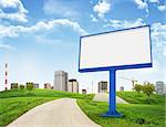 Tall buildings, green hills and road with large billboard against sky with clouds. Architectural concept