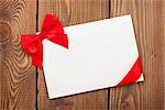 Valentines day greeting card with red ribbon over wooden background