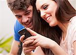young woman and man watching something fun on a mobile phone