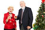 Senior couple laughing and drinking champagne at a Christmas party.  Isolated on white.