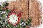 Christmas wooden background with clock, snow fir tree and copy space