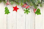 Christmas wooden background with fir tree and decor. View from above with paper for copy space