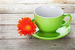 Coffee cup and gerbera flower on wooden table