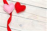 Valentines day background with toy hearts and ribbon over white wooden table background