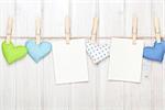 Two photo frames and valentines day toy hearts over white wooden background