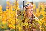 Portrait of thoughtful young woman standing in autumn vineyard