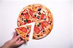 Male hand picking tasty pizza slice, studio shot on white background