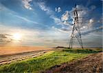 Electric pole in the autumn field at sunrise