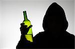Silhouette of hooded anonymous alcoholic with a wine bottle
