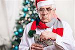 Senior man with money on Christmas background