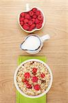 Healty breakfast with muesli, berries and milk on wooden table