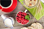 Healthy breakfast with muesli, berries and milk. On wooden table