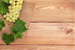 Bunch of white grapes on wooden table background with copy space