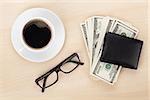 Money cash, glasses and coffee cup on wooden table