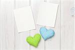 Photo frames and valentines toy hearts over wooden table background