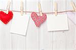 Photo frames and valentines toy hearts over wooden background