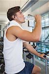 Fit man working out on the exercise bike at the gym