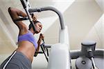 Fit woman using the weights machine for her arms at the gym