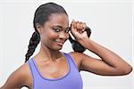 Fit woman smiling at camera holding kettlebell at the gym