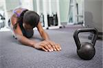 Fit woman working out with kettlebell at the gym