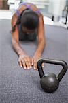 Fit woman working out with kettlebell at the gym