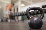 Focus on large black kettlebell in weights room at the gym