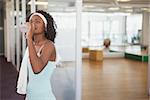 Fit woman drinking water in fitness studio at the gym