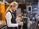 Barmaid pulling a glass of beer in a bar