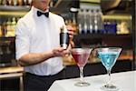 Attractive bar man making a cocktail in a bar