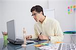 Focused designer using digitizer at his desk in his office