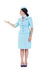 Pretty air hostess showing with hand on white background