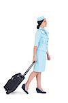 Pretty air hostess walking with suitcase on white background