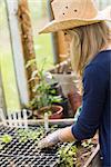 Pretty blonde gardening in greenhouse at home in the garden