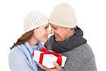 Casual couple in warm clothing holding gift on white background