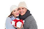 Casual couple in warm clothing holding gift on white background